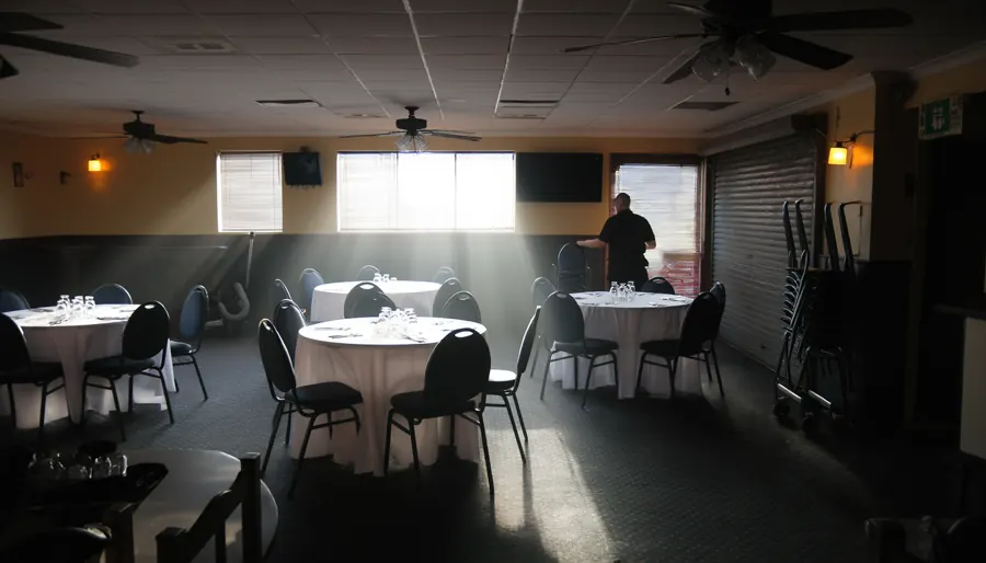 A pub function room set up an hour before an event - tables laid, chairs straightened, one duty manager at the far end of the room.